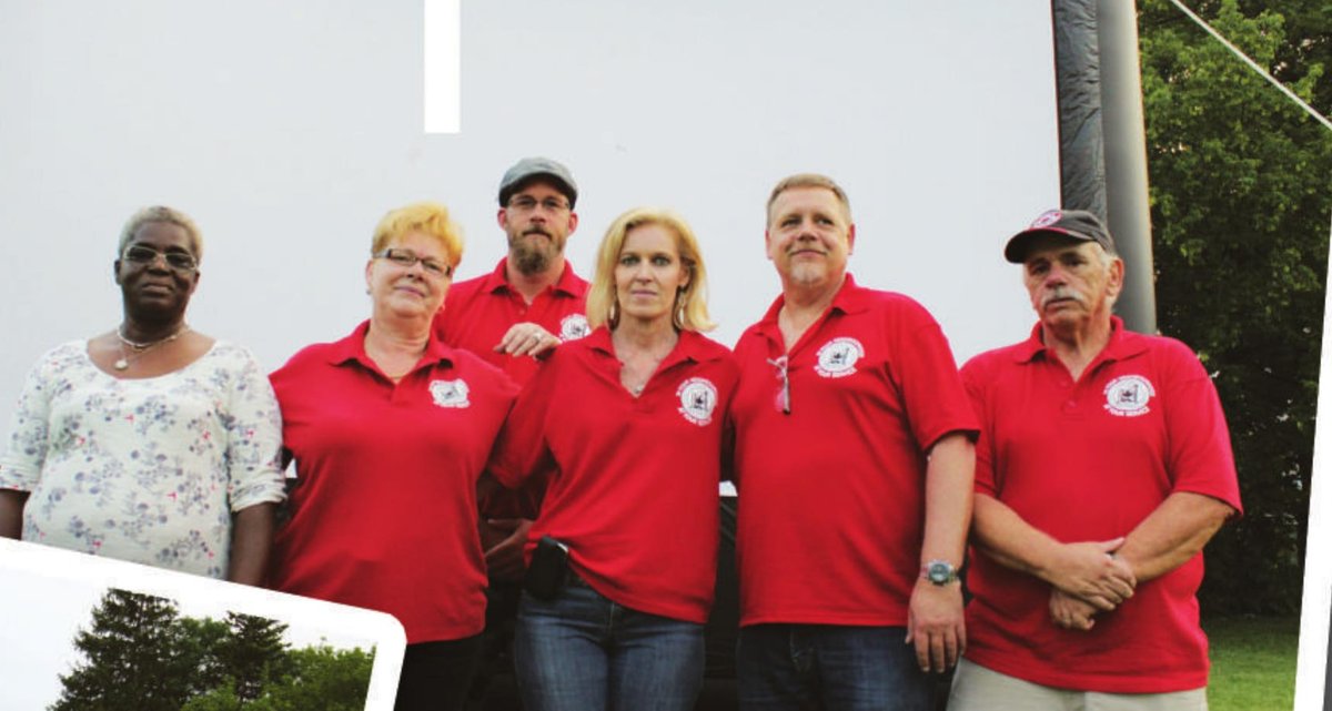 Local 416 members posing with a resident in front of the inflatable movie screen at a Family Movie Night